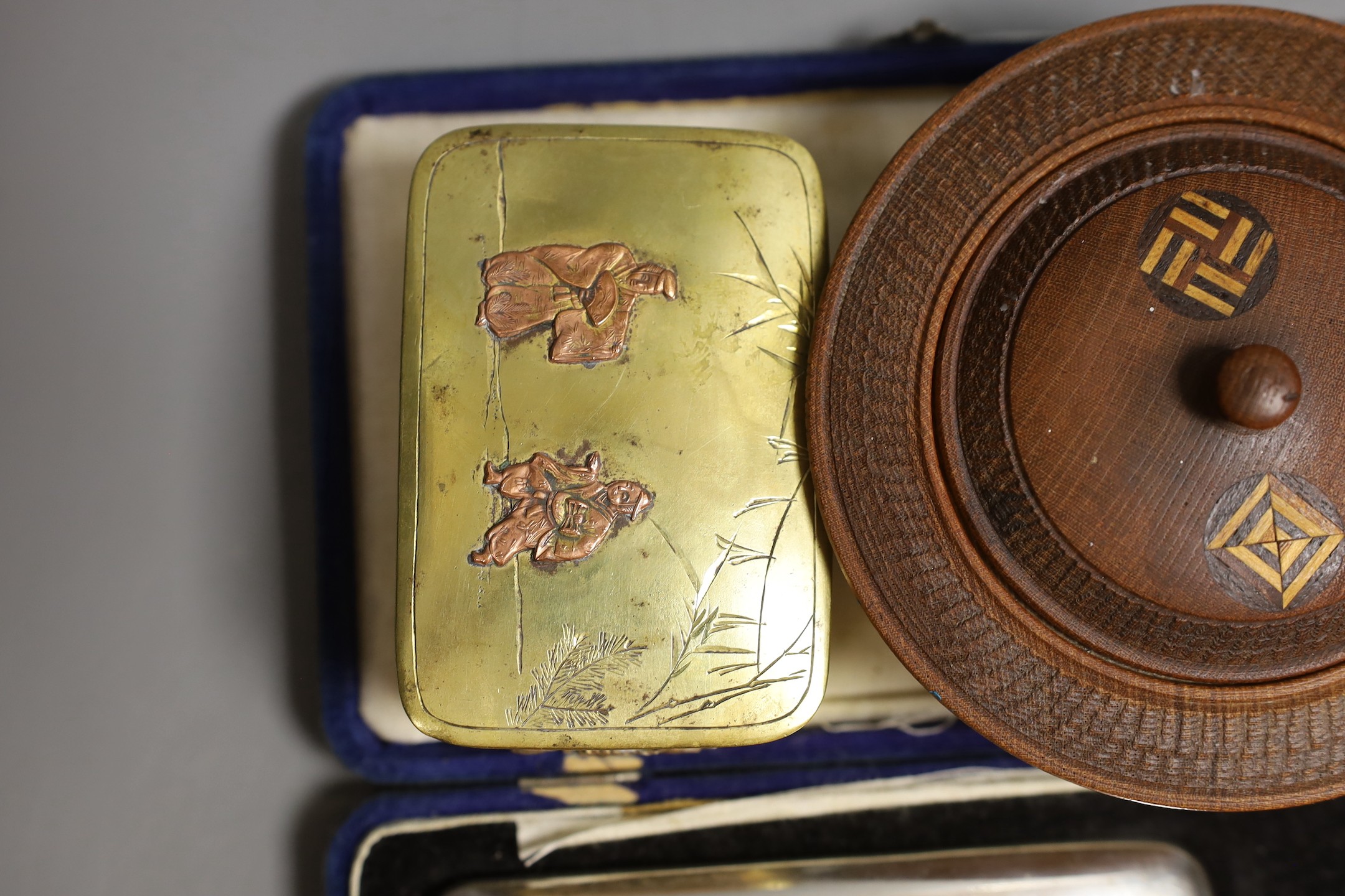 A Japanese sterling cigarette case, vesta, a locket, box and carved circular bowl and cover, bowl and cover 11 cms diameter.